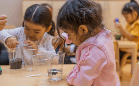 Girls experimenting with food coloring in water